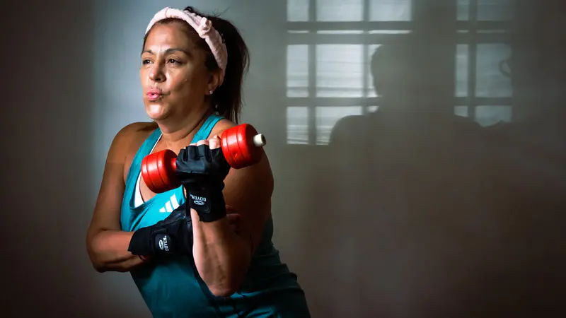 Woman doing a dumbbell curl during a strength workout