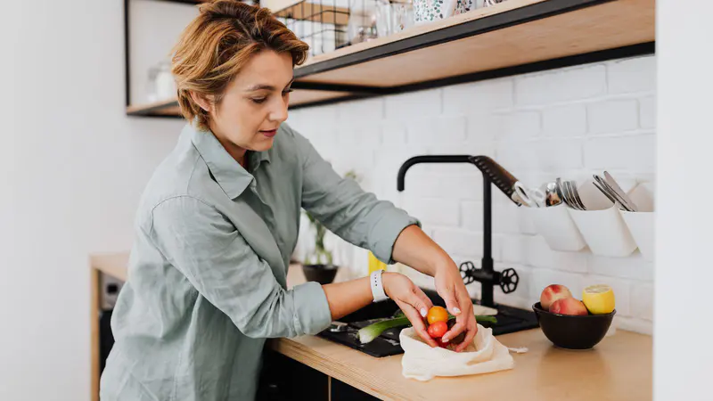 Woman preparing fresh vegetables in a bright kitchen