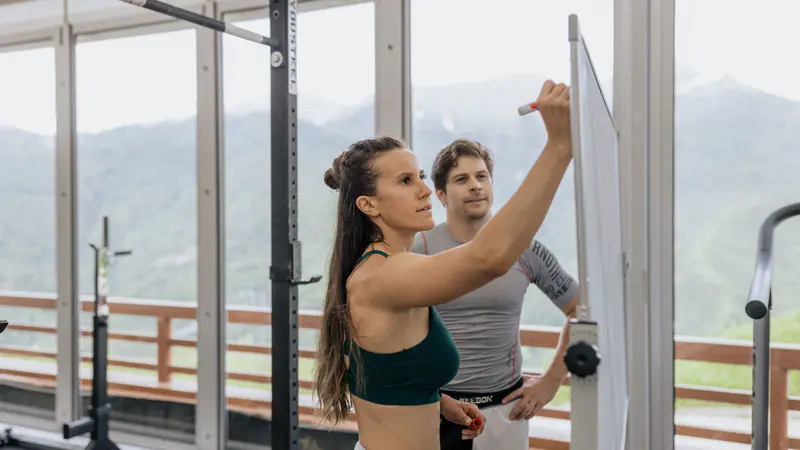 A coach writing a training plan on a whiteboard in the gym