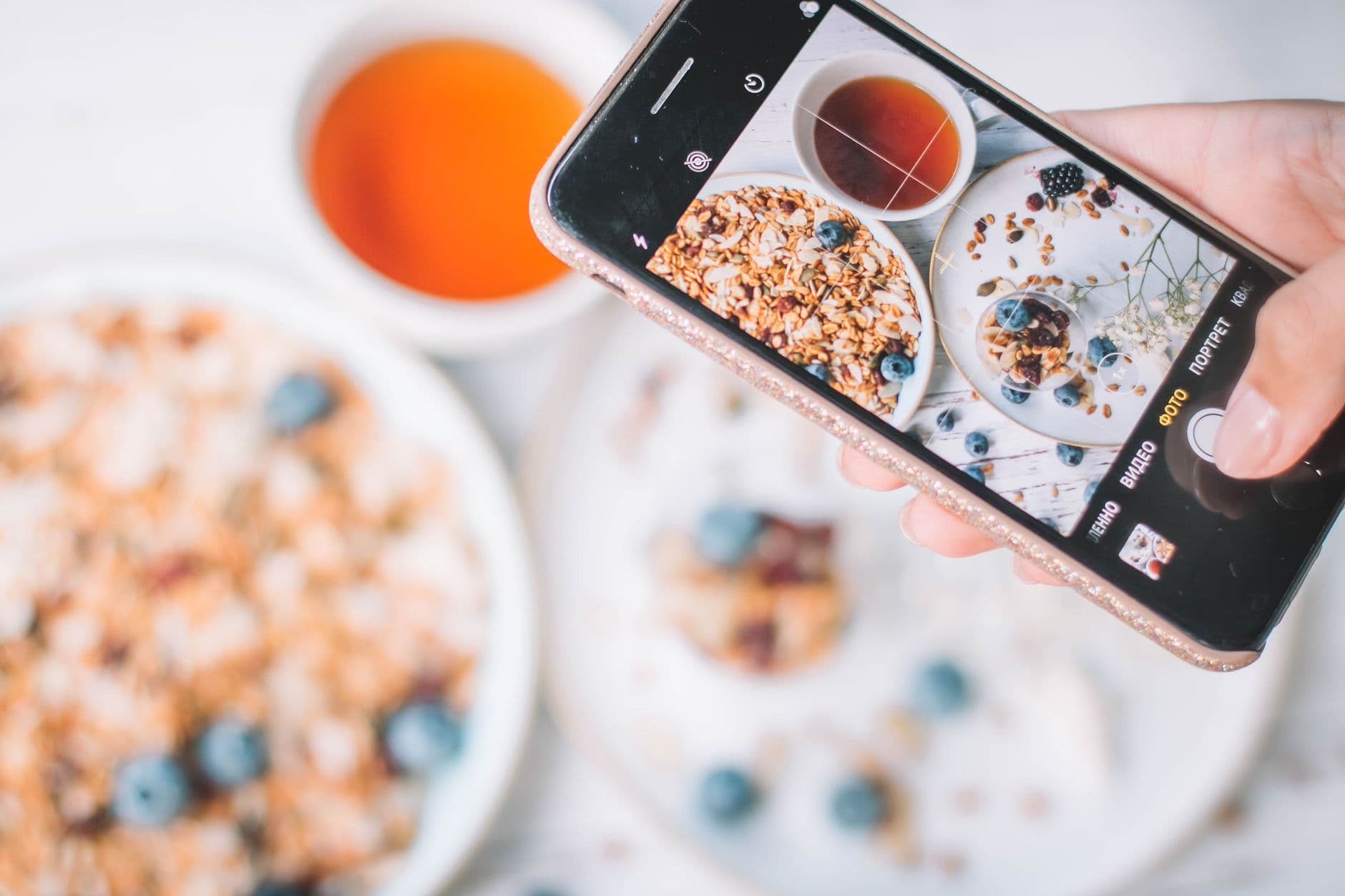 Someone photographing a healthy breakfast bowl with their phone