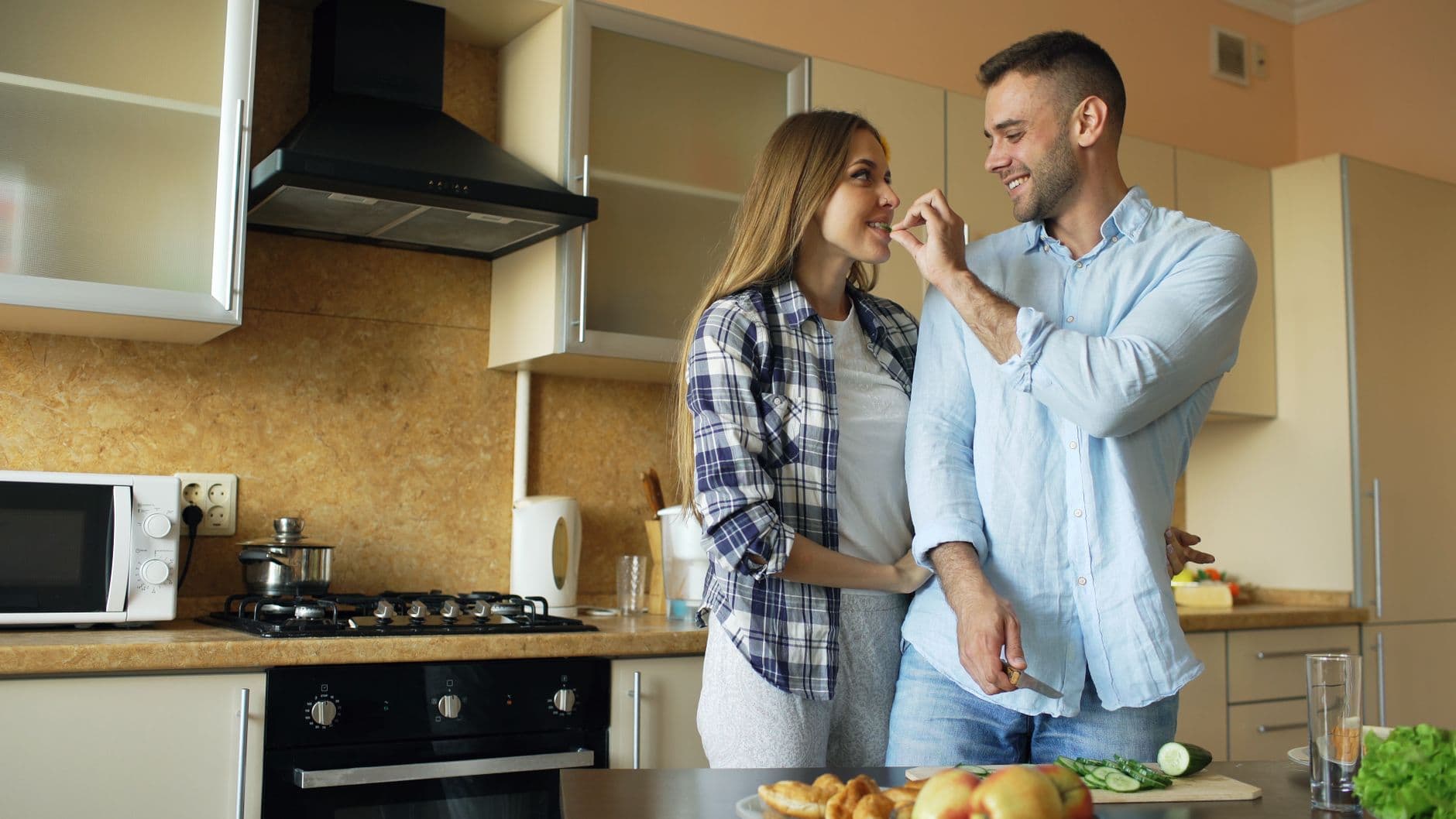 A happy couple cooking a healthy meal together in their kitchen